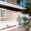 White fence with greenery and house